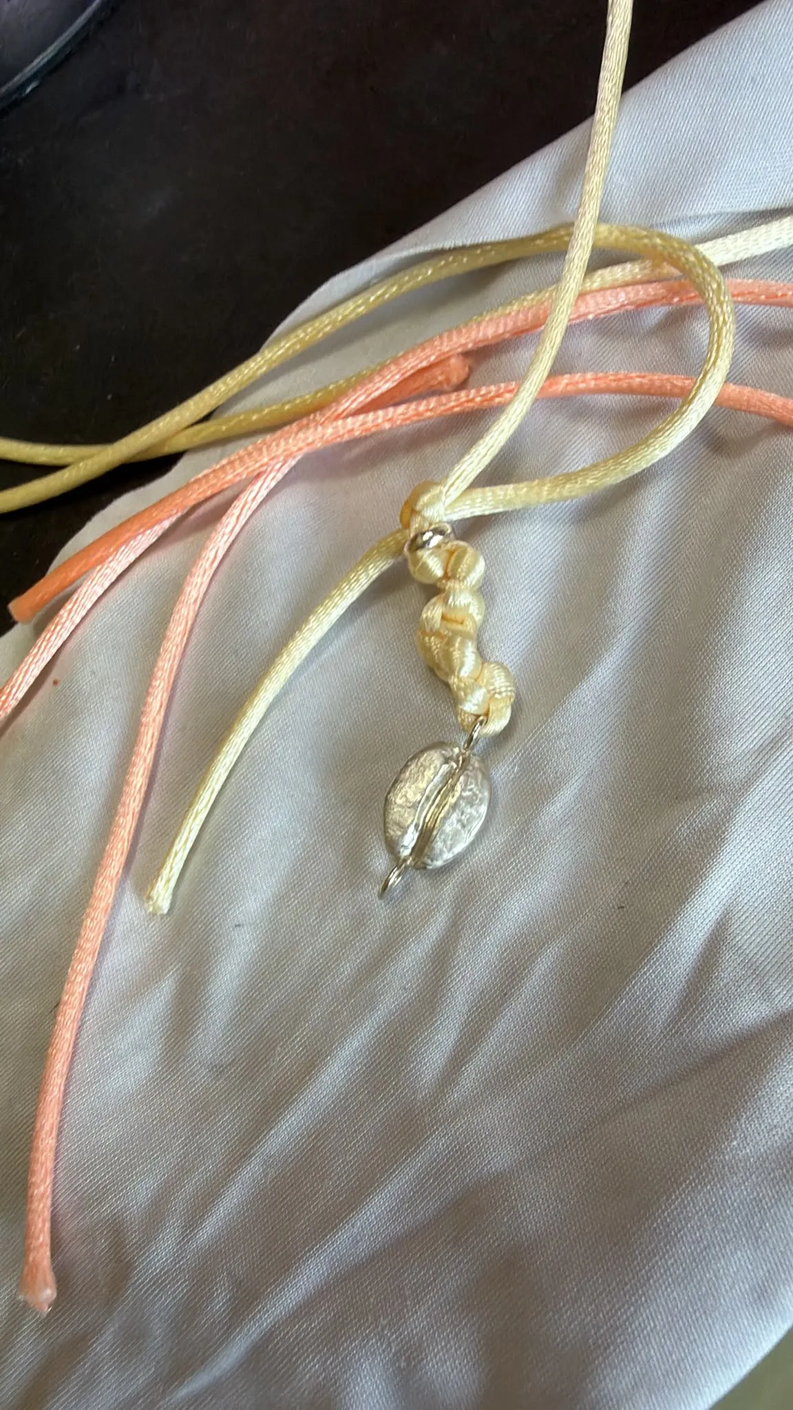 Le grain d'argent sur des cordons teints à la main, café et cacao.
